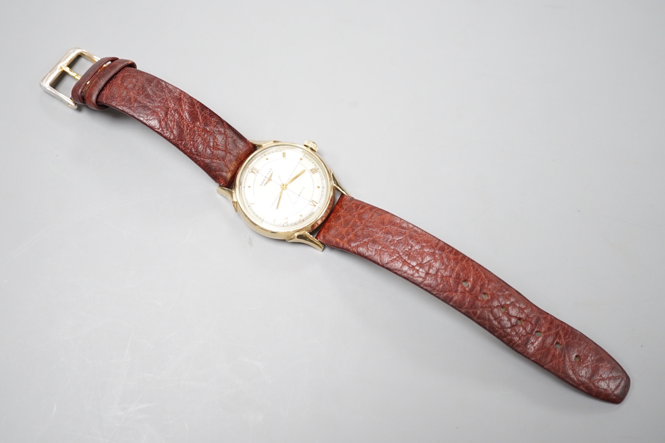 A gentleman's 10k gold filled Longines automatic wrist watch, the 'quartered' dial with Roman and dot markers, on a brown leather strap, case diameter 33mm.